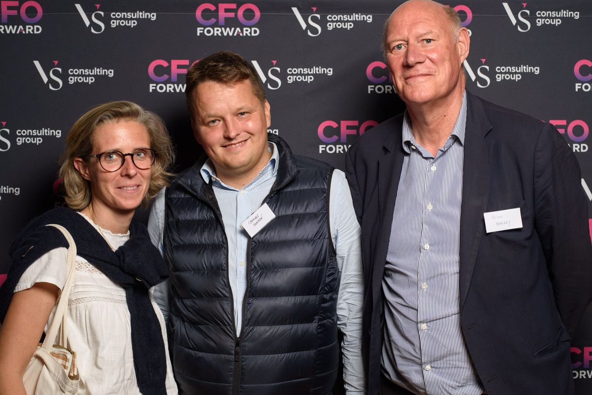 Three guests in front of the CFO Forward wall